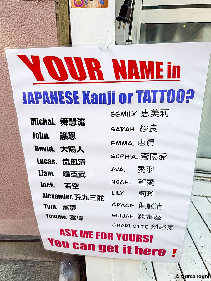Cartello con nomi tradotti in giapponese per kanji e tatuaggi.