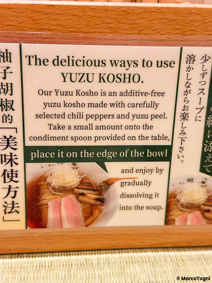 Cartello informativo con istruzioni sull'uso dello yuzu kosho presso il ristorante Ramen Kamo to Negi.
