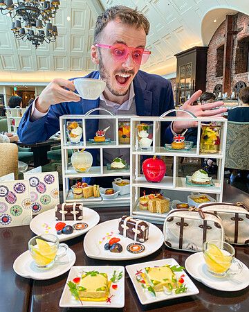 Marco Togni elegante con dolci su vassoi a più livelli durante afternoon tea.