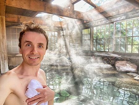 Marco Togni in un onsen a Yufuin, con vapore e luce naturale.