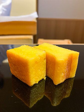 Tamagoyaki a Sushi Masashi posato su un piano nero lucido.