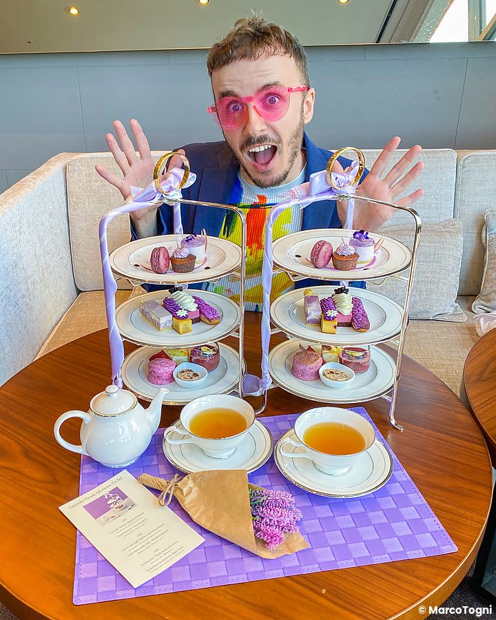 Afternoon tea a tema lavanda con dolci, tazze di tè e Marco Togni sorridente.