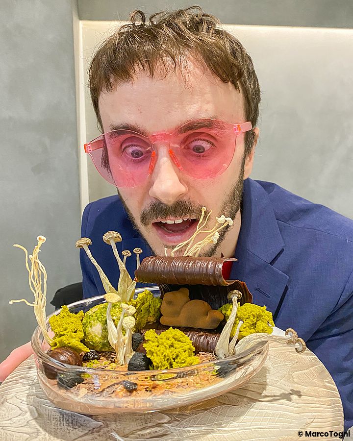 Marco Togni con occhiali rosa guarda un dolce con funghi servito in un piatto di vetro presso Le Musée a Ginza.