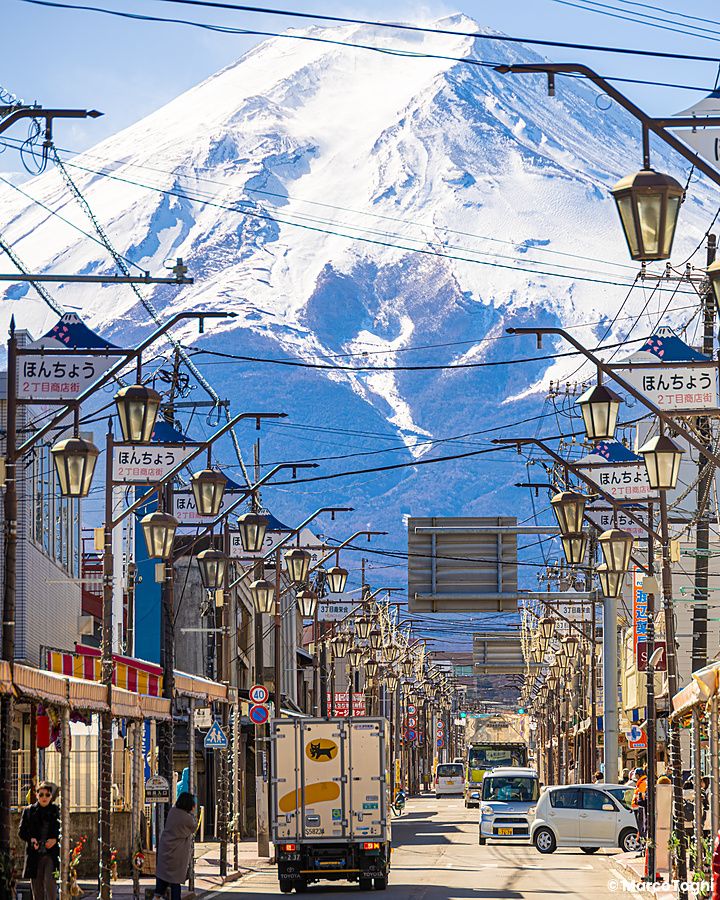 Una strada commerciale a Fujiyoshida con il Monte Fuji sullo sfondo.
