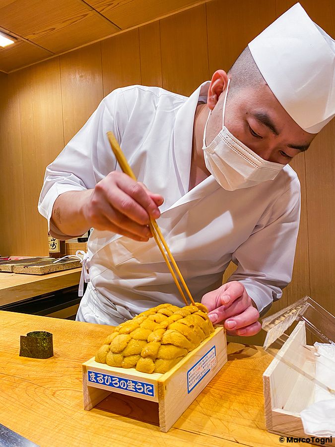Uno chef prepara Uni (riccio di mare) fresco in un contenitore di legno presso il ristorante Ginza Iwa a Tokyo.