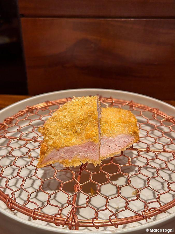 Una porzione di tonkatsu servita su una griglia metallica presso il ristorante Ginza Katsukami a Tokyo.