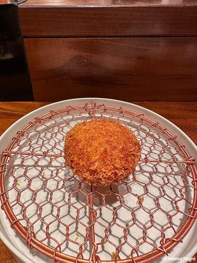 Un piatto fritto servito su una griglia metallica al ristorante Ginza Katsukami a Tokyo.