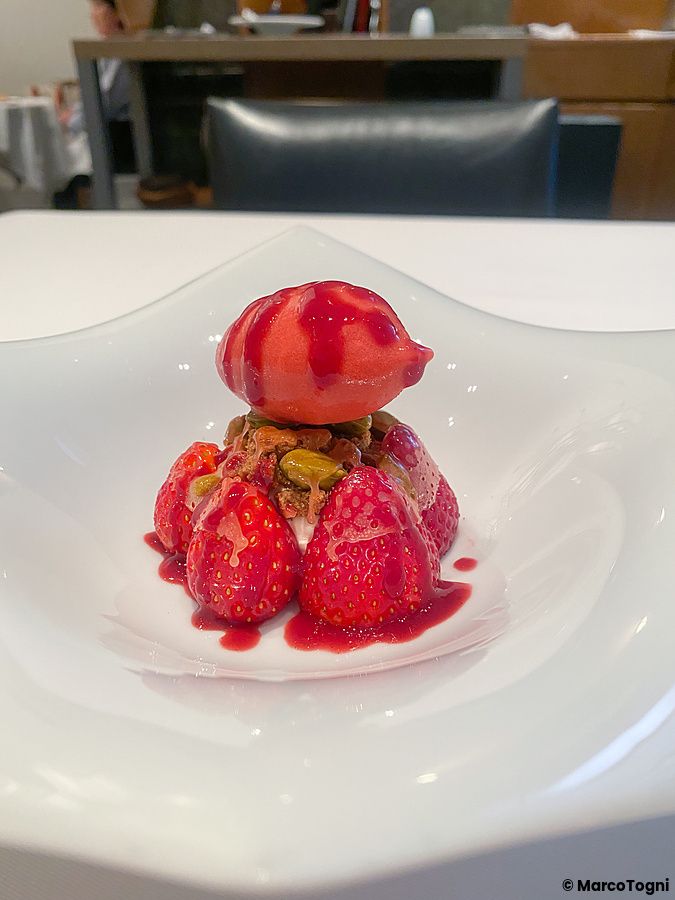 Un piatto bianco moderno con fragole, una pallina di gelato di fragole e una parte croccante al ristorante Koji Shimomura.