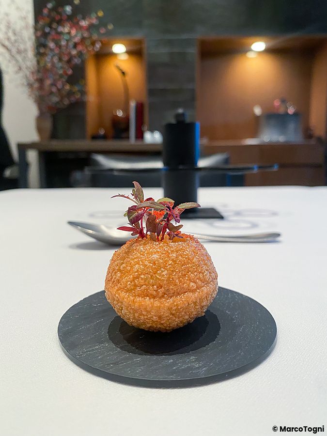 Palla fritta con avocado, croccantissima e molto saporita, servita su un disco di ardesia presso Edition Koji Shimomura.