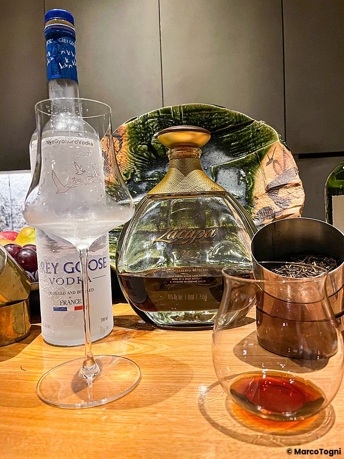 Bottiglie di Grey Goose e Zacapa XO sul bancone del Mixology Salon a Ginza, Tokyo, con bicchieri da degustazione.