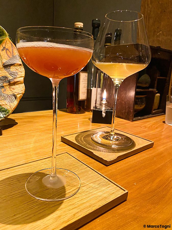 Due eleganti calici con cocktail su sottobicchieri di legno presso il Mixology Salon nel quartiere Ginza a Tokyo.