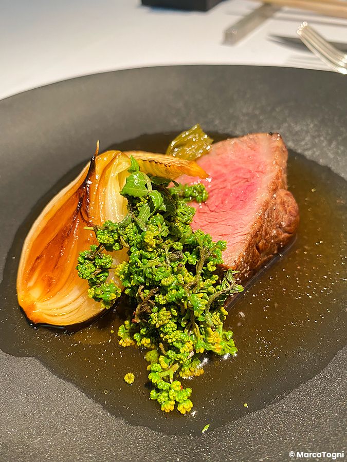 Carne di Kobe con pepe sansho fresco servita in un piatto scuro presso il ristorante Narisawa a Tokyo.