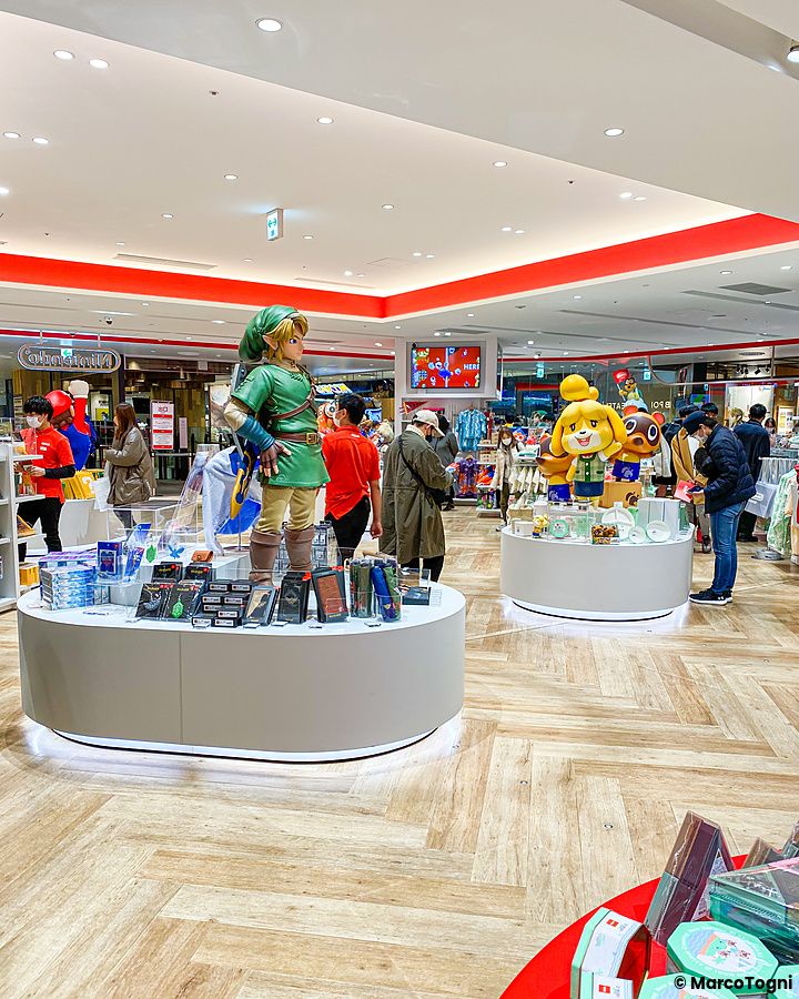 Veduta interna del Nintendo Store al Shibuya Parco di Tokyo con una statua di Link e diversi visitatori tra gli scaffali.