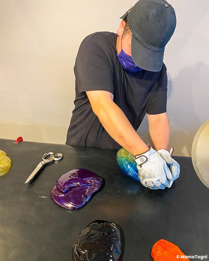 Una persona lavora una massa di zucchero colorata durante la preparazione caramelle a Papabubble in un laboratorio.