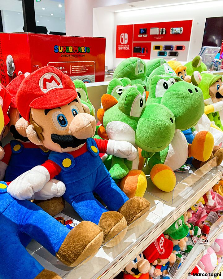 Peluche di Mario e Yoshi esposti sugli scaffali all'interno del Nintendo Store.