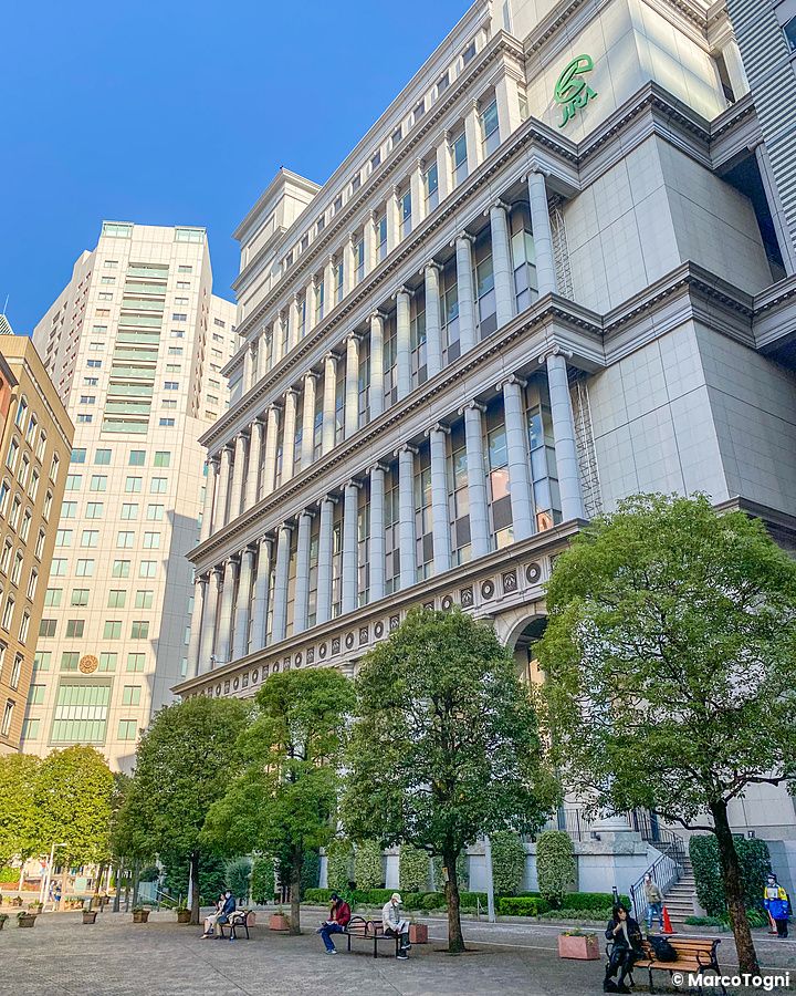 Edificio classico nel quartiere italiano a Tokyo con persone in piazza.