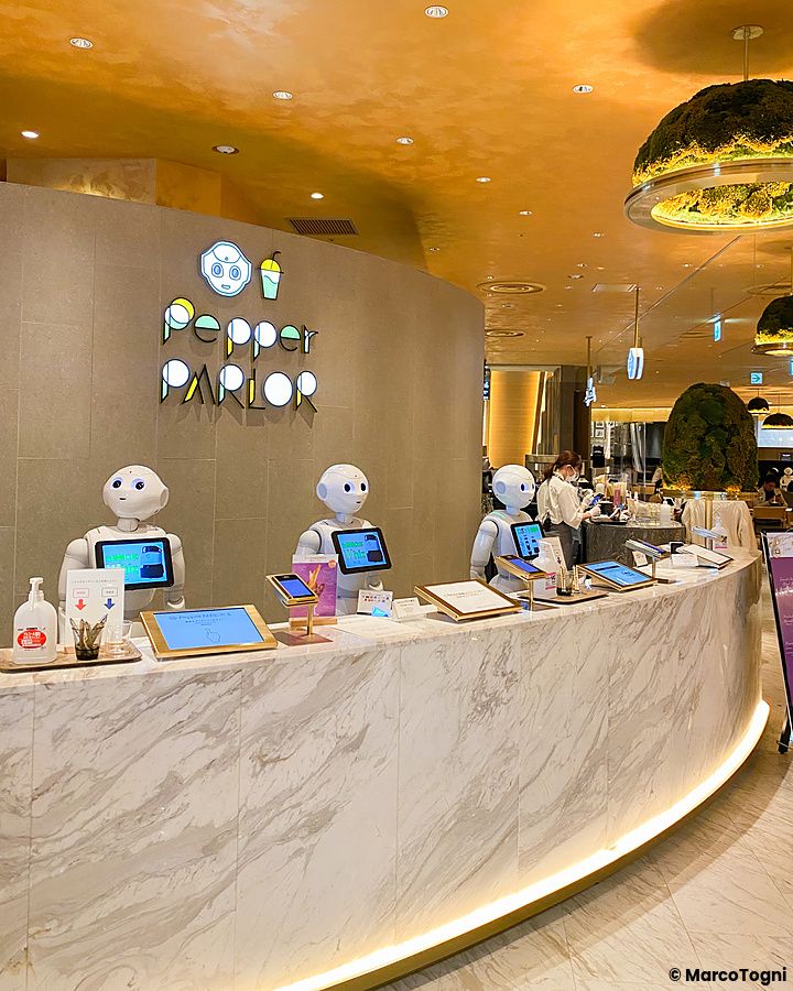 Tre robot Pepper sono posizionati sul bancone di marmo all'interno del ristorante Pepper Parlor a Shibuya.