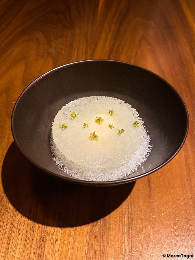 Un pre dessert al sapore di anice servito in una ciotola scura su un tavolo di legno presso il ristorante Le Sputnik.