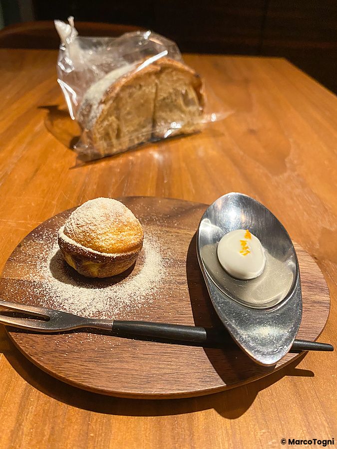 Una piccola pasticceria a Le Sputnik composta da una brioche e una crema servita su un vassoio di legno a Tokyo.