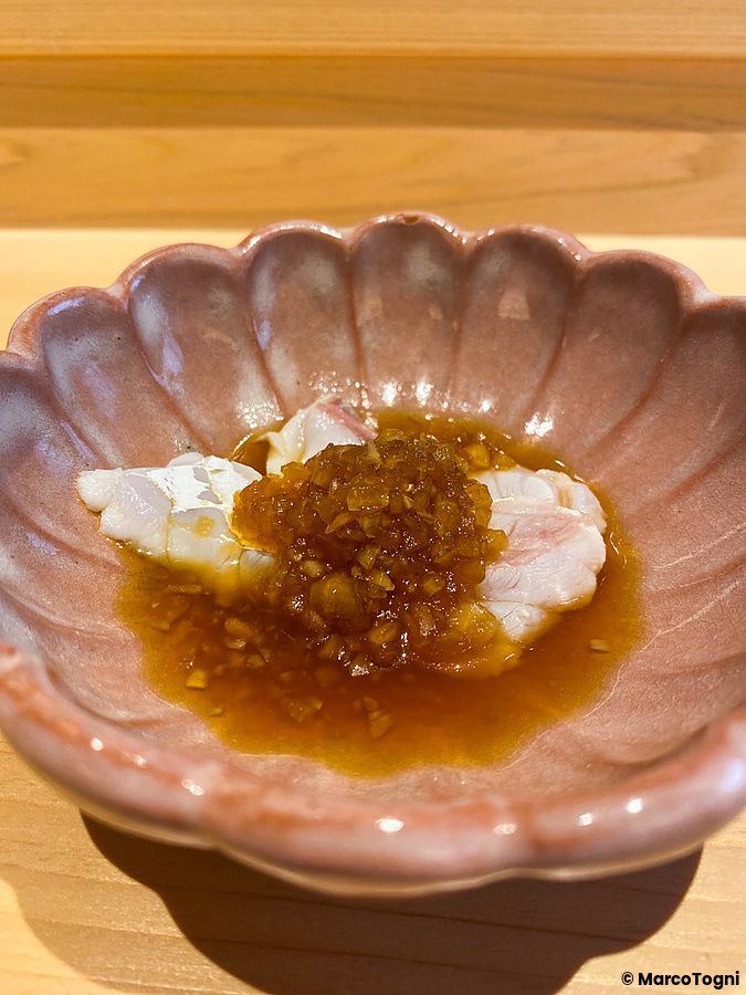 Una cernia con salsa agrodolce servita in una ciotola di ceramica rosa da Sushi Masashi a Tokyo.