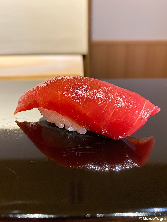 Nigiri di tonno su piatto nero riflettente in un ristorante a Tokyo.