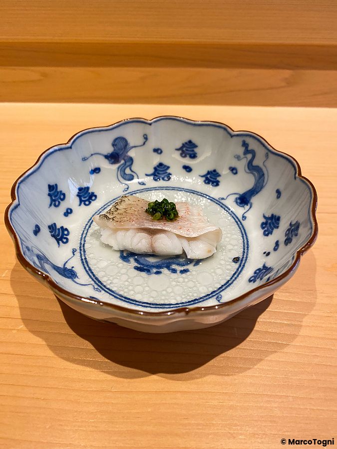 Un filetto di pesce con salsa molto leggera servito in una ciotola di ceramica decorata da Sushi Masashi.