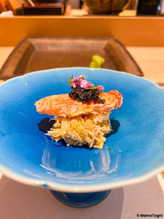Granchio con caviale servito in una ciotola di ceramica blu presso il ristorante Sushi Takeuchi a Tokyo.