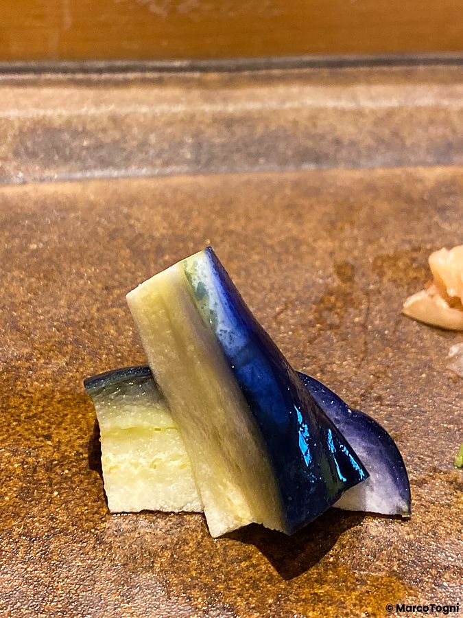 Una melanzana tagliata a pezzi su un piatto da Sushi Takeuchi.