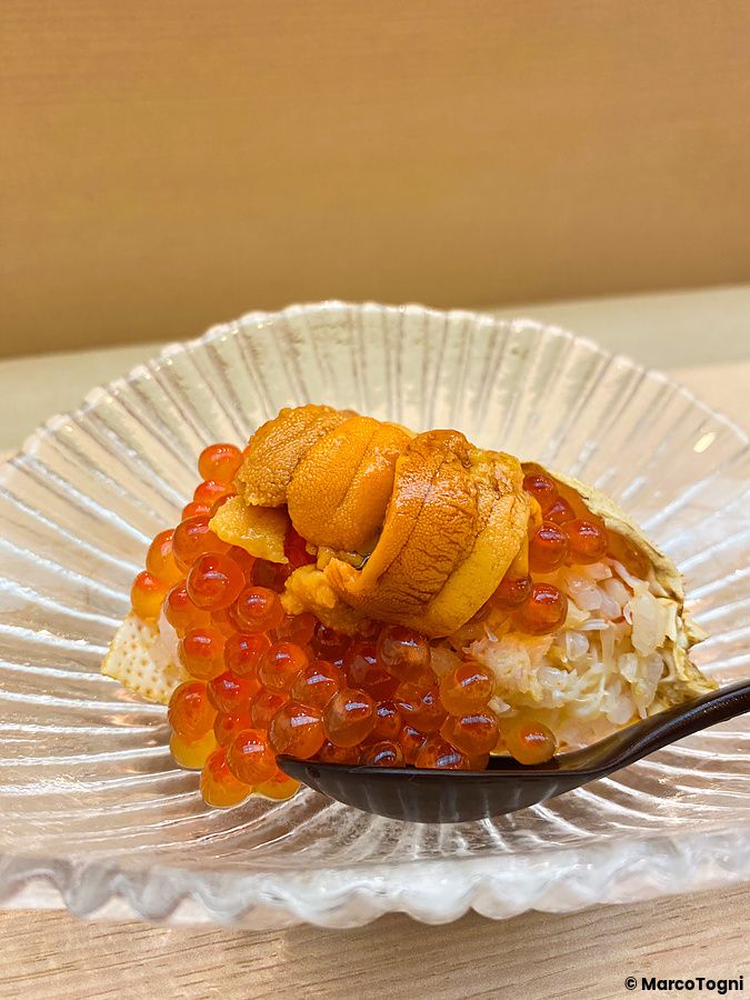 Piatto con granchio, ikura e uni servito in una ciotola di vetro trasparente presso il ristorante Sushi Tou a Tokyo.