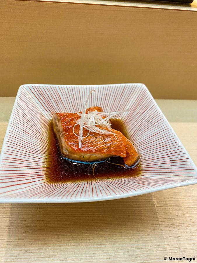 Un piatto di kinmedai con salsa leggermente dolce presentato elegantemente su un piattino decorato da Sushi Tou.