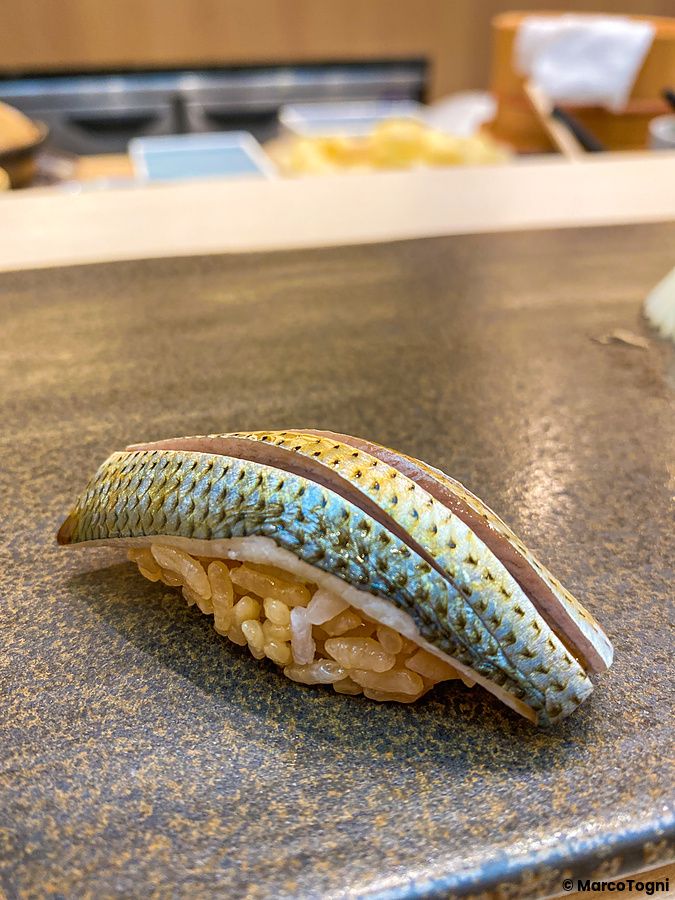 Un nigiri di kohada servito su un piatto scuro presso da Sushi Tou a Tokyo.