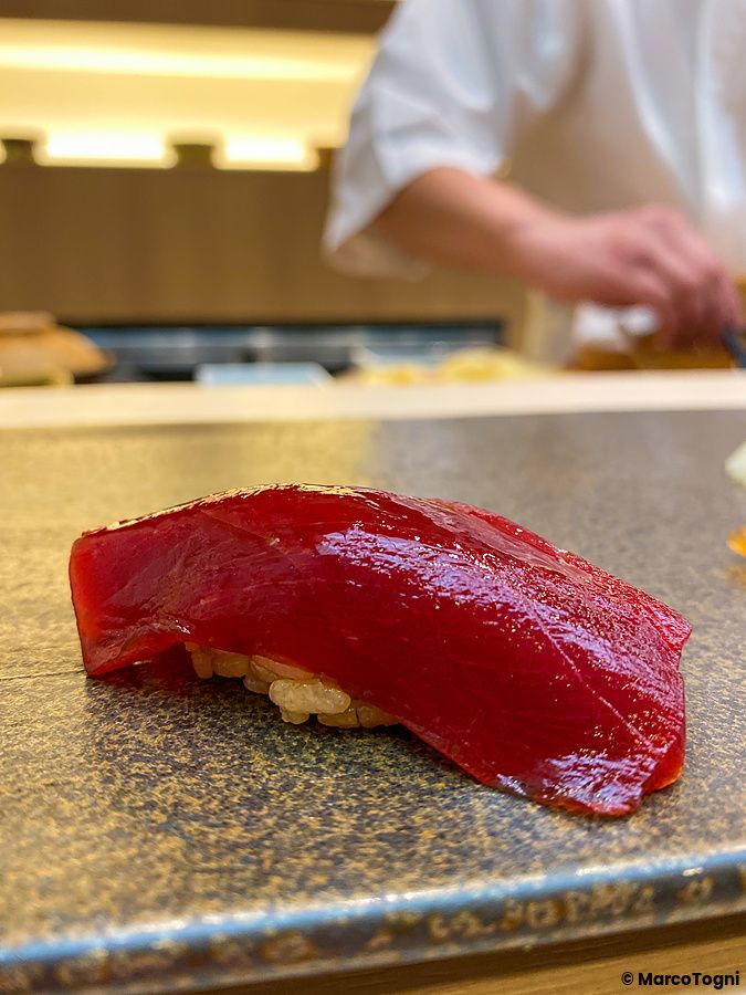 Un nigiri di tonno fresco poggiato su un piatto di pietra scura all'interno di Sushi Tou a Tokyo.