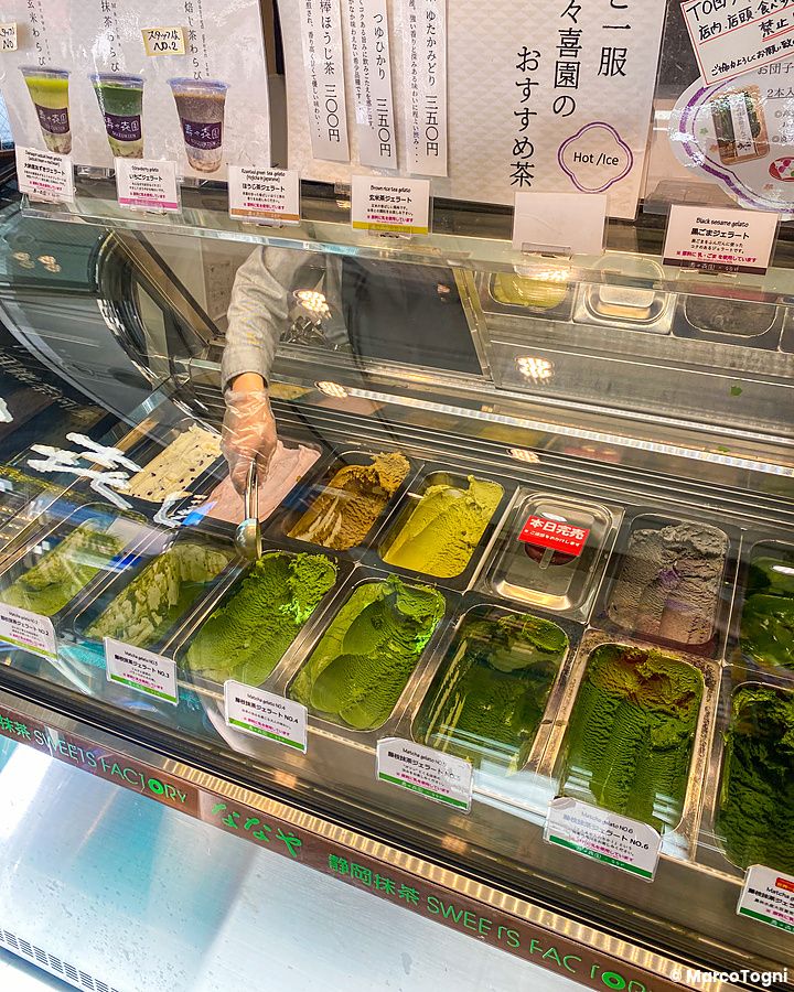 Una persona serve gelati al matcha in diversi gradi di intensità presso il bancone della gelateria Nanaya a Tokyo.