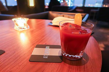Un cocktail rosso con guarnizione di agrumi su un tavolo al Bar Bellovisto presso il Cerulean Tower Tokyu Hotel a Shibuya.