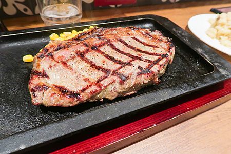 Una bistecca di manzo grigliata su una piastra di ghisa nera presso il ristorante Steak Lodge in Giappone.