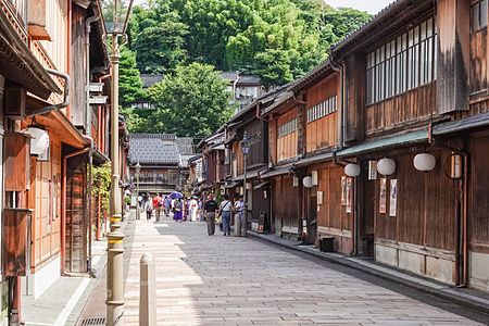 Strada di Higashi Chaya a Kanazawa con edifici in legno e persone che passeggiano.