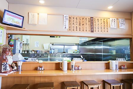 Bancone in legno con sgabelli e cucina a vista nel ristorante Midoriya Ramen a Hirosaki.