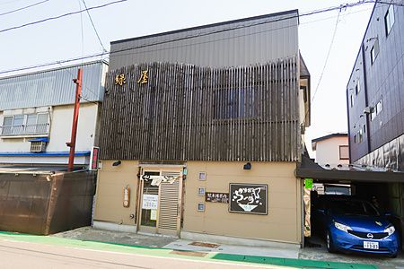 La facciata esterna del ristorante Midoriya Ramen ad Hirosaki con rivestimento in legno e insegna decorata.