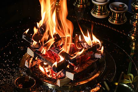 Fiamme ardenti su una base metallica durante una cerimonia rituale all'interno del Tempio Gyokuzoin a Nara.