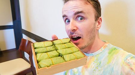 Marco Togni con un vassoio di sushi di Nara avvolto in foglie verdi.