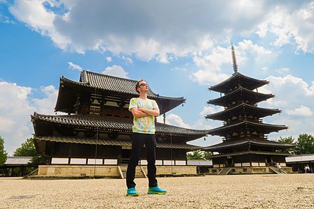 una persona davanti al tempio Horyuji con cielo nuvoloso.