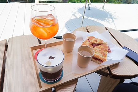 Un vassoio con cibo e bevande su un tavolino di legno in terazza a Starbucks Reserve a Nakameguro, Tokyo.
