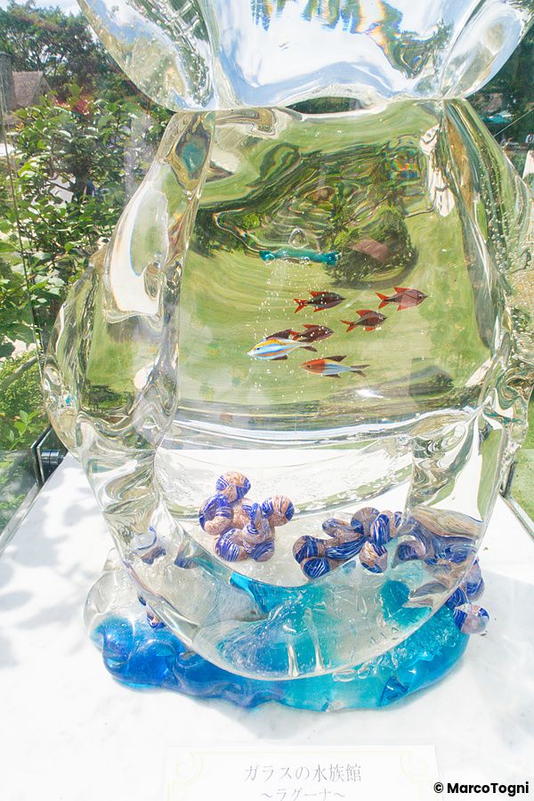Scultura in vetro a forma di acquario con pesci e coralli esposta presso l'Hakone Glass Forest Museum in Giappone.