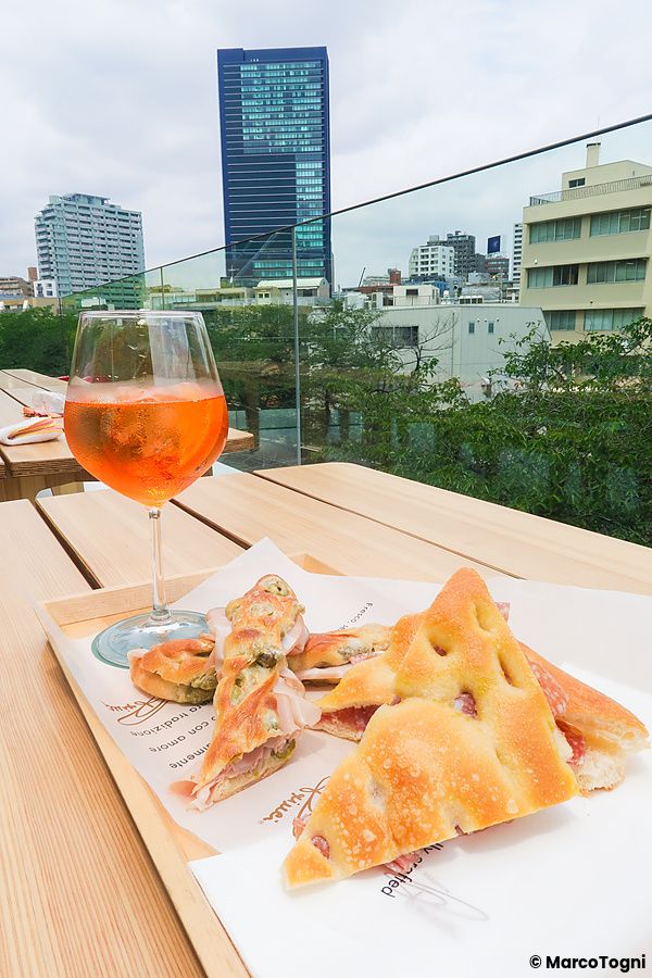 Uno spritz e della focaccia su un tavolo in legno presso la terrazza di Starbucks Reserve a Nakameguro, Tokyo.
