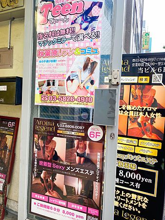 Cartelloni pubblicitari per massaggi ad Akihabara, Tokyo con immagini e testi colorati.