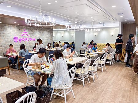 L'interno del ristorante "a Happy Pancake" con persone sedute ai tavoli e lampadari classici al soffitto.