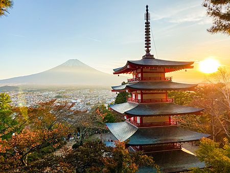Il Monte Fuji svetta dietro la Pagoda Chureito durante un tramonto luminoso in Giappone.