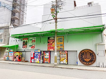 La facciata di Catboy Milk Machine ad Osaka con numerosi distributori automatici colorati e insegne di prezzi economici.