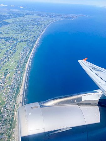 Veduta aerea dal finestrino di un aereo che sorvola la costa e il mare in Giappone.