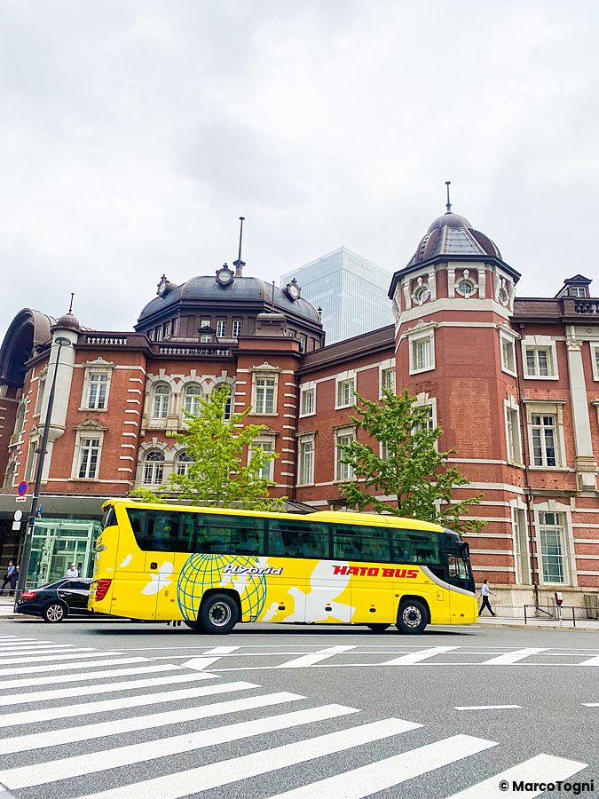 Un bus turistico Hato no Bus giallo davanti alla stazione di Tokyo nel quartiere Marunouchi.
